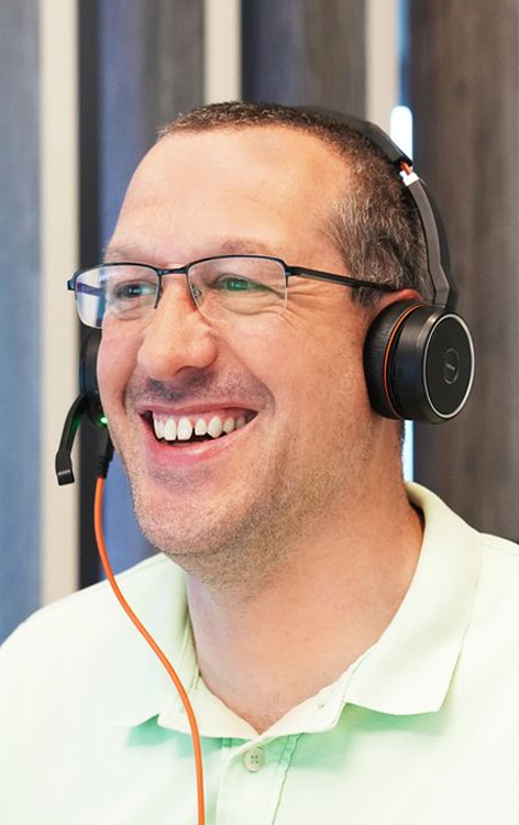 Lachender Mitarbeiter von PropertyExpert mit Headset